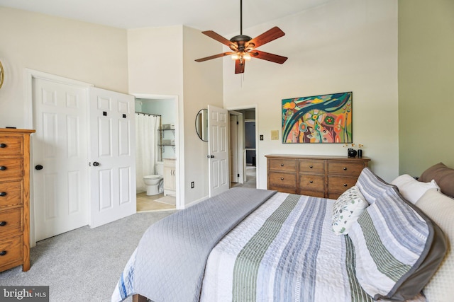 bedroom featuring carpet, a high ceiling, ensuite bathroom, and a ceiling fan