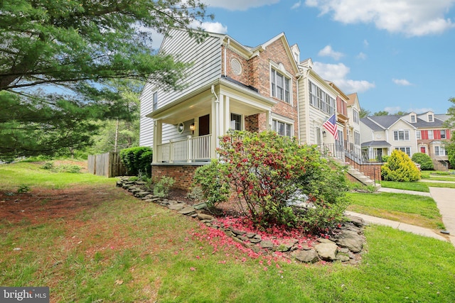 view of side of property with brick siding, a residential view, and a porch