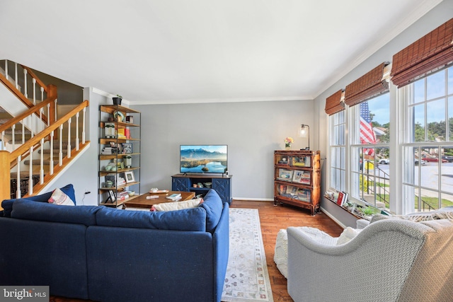 living area featuring ornamental molding, stairs, wood finished floors, and baseboards