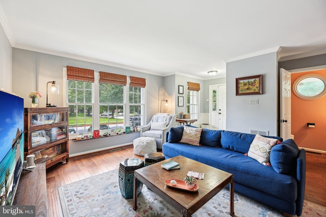 living area with plenty of natural light, hardwood / wood-style flooring, and crown molding