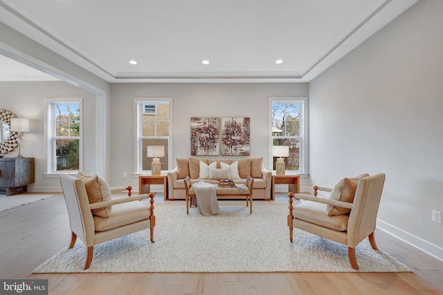 living room featuring healthy amount of natural light, wood finished floors, baseboards, recessed lighting, and a raised ceiling