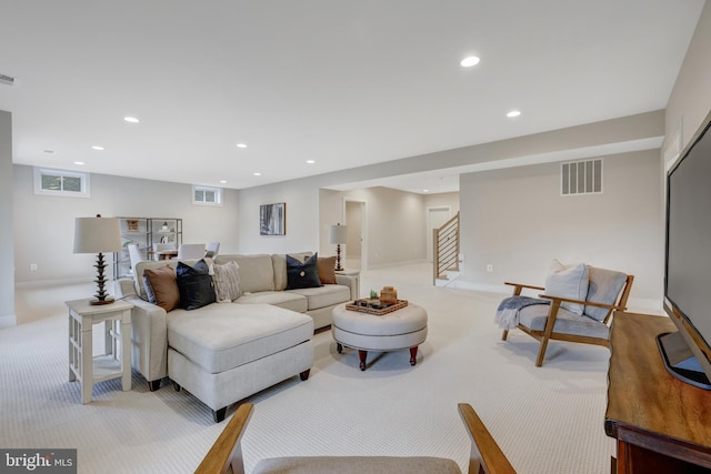 living area featuring light colored carpet, stairs, and recessed lighting