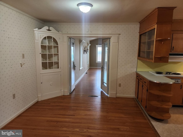 unfurnished dining area with wood finished floors, crown molding, wallpapered walls, and baseboards