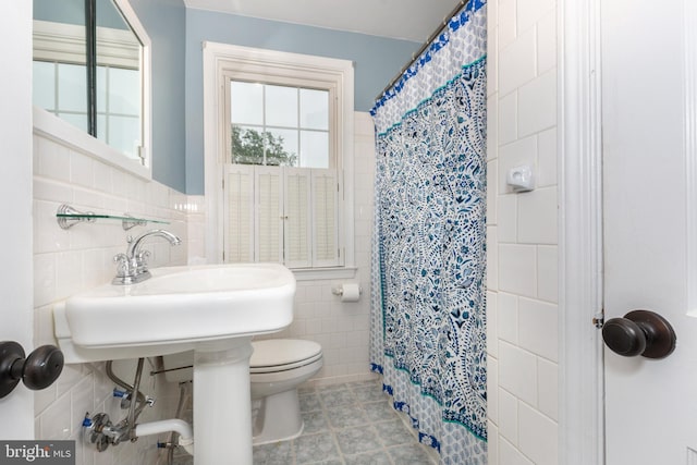 full bathroom with tile walls, a shower with shower curtain, toilet, and tile patterned floors
