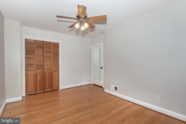unfurnished bedroom with baseboards, light wood-style floors, a closet, and a ceiling fan