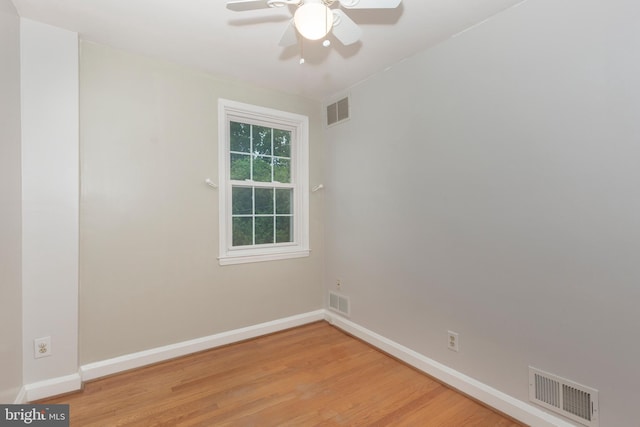 spare room featuring baseboards, light wood-style floors, and a ceiling fan