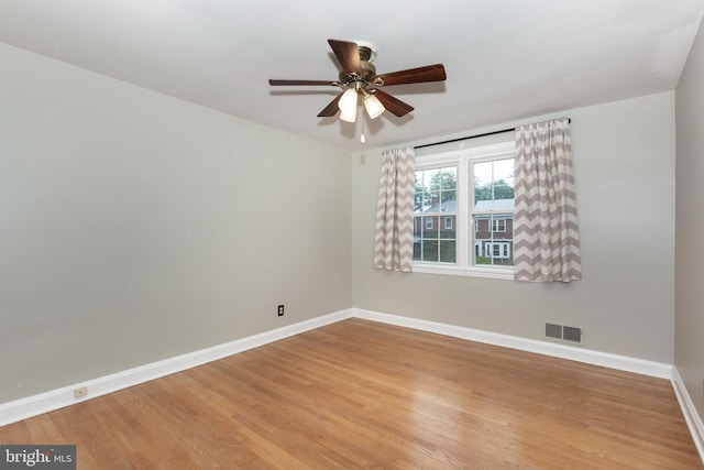 spare room with baseboards, a ceiling fan, and light wood finished floors