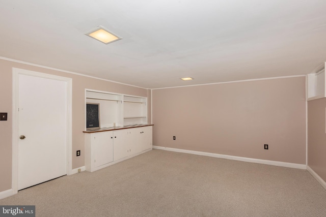 unfurnished living room featuring light carpet, baseboards, and crown molding
