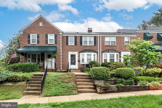 multi unit property with brick siding and a chimney