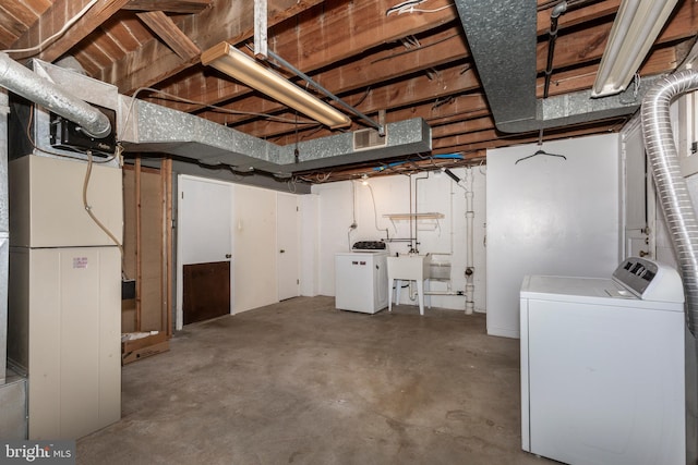 unfinished below grade area featuring washer and dryer and a sink