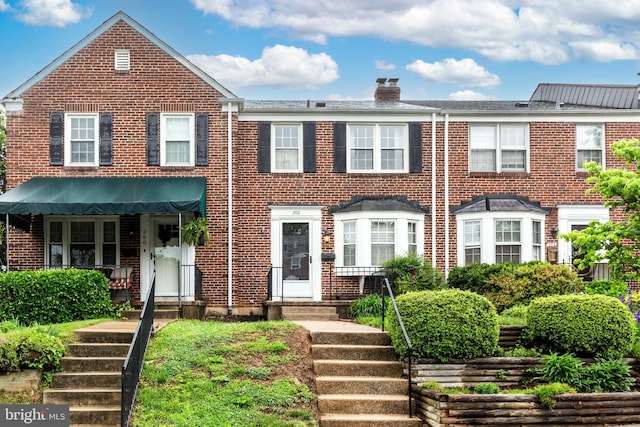 multi unit property with brick siding and a chimney