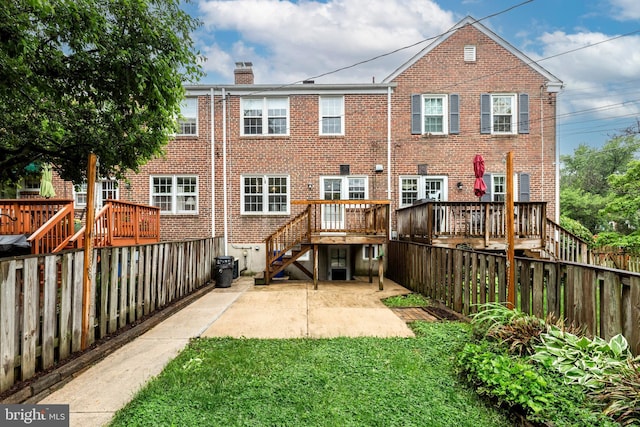 rear view of house featuring brick siding, a patio area, and a chimney