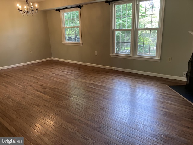 9118 Bobwhite Cir, Gaithersburg, MD 20879 - empty room featuring dark wood-type flooring, plenty of natural light, a chandelier, and baseboards