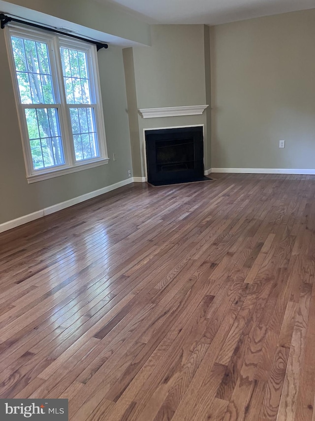 9118 Bobwhite Cir, Gaithersburg, MD 20879 - unfurnished living room featuring hardwood / wood-style floors, a fireplace with flush hearth, and baseboards