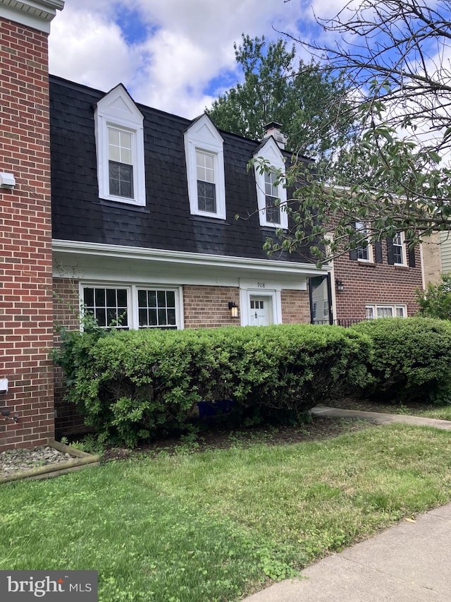 9118 Bobwhite Cir, Gaithersburg, MD 20879 - view of front facade featuring brick siding, a front lawn, a chimney, and roof with shingles