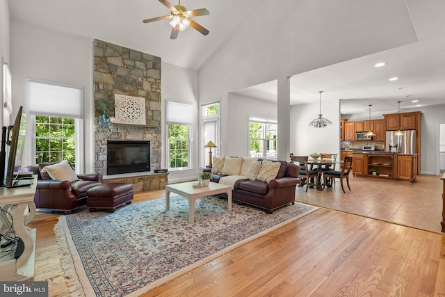 301 Reserve Gate Ter, Silver Spring, MD 20905 - living room with ceiling fan, high vaulted ceiling, light wood-style floors, a stone fireplace, and recessed lighting