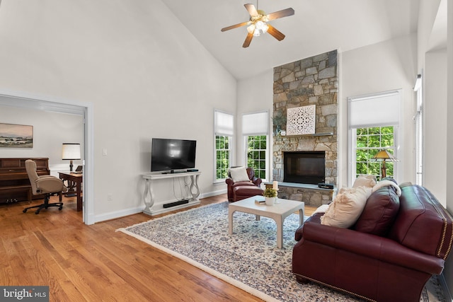 301 Reserve Gate Ter, Silver Spring, MD 20905 - living area featuring high vaulted ceiling, a ceiling fan, wood finished floors, a stone fireplace, and baseboards