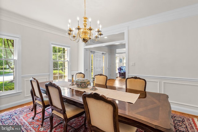 301 Reserve Gate Ter, Silver Spring, MD 20905 - dining space with a chandelier, crown molding, a decorative wall, wainscoting, and light wood-style floors