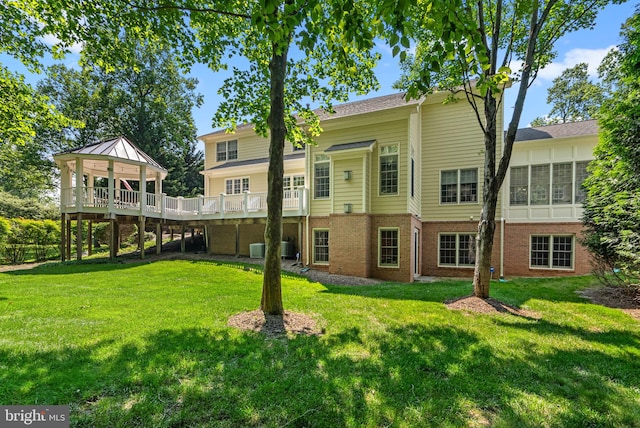 301 Reserve Gate Ter, Silver Spring, MD 20905 - back of house featuring brick siding, a yard, a gazebo, a wooden deck, and central AC unit