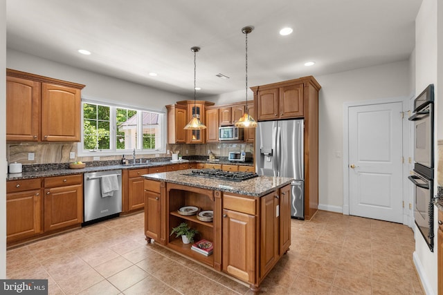 301 Reserve Gate Ter, Silver Spring, MD 20905 - kitchen featuring appliances with stainless steel finishes, backsplash, dark stone counters, brown cabinetry, and a sink