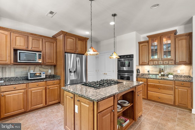 301 Reserve Gate Ter, Silver Spring, MD 20905 - kitchen featuring stainless steel appliances, tasteful backsplash, dark stone counters, glass insert cabinets, and brown cabinetry
