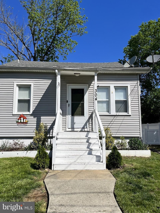 view of front of property featuring a front yard and roof with shingles