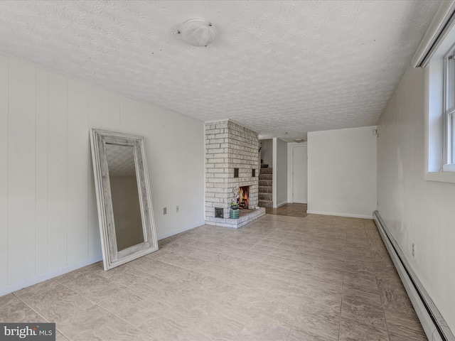 3906 Highland Ridge Rd, Berkeley Springs, WV 25411 - unfurnished living room with a baseboard radiator, a textured ceiling, a fireplace, and baseboards