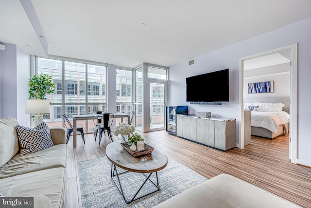 living area featuring a wall of windows and light wood-style flooring