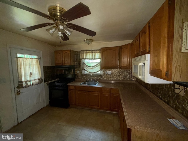 kitchen featuring black gas stove, a sink, white microwave, decorative backsplash, and brown cabinets