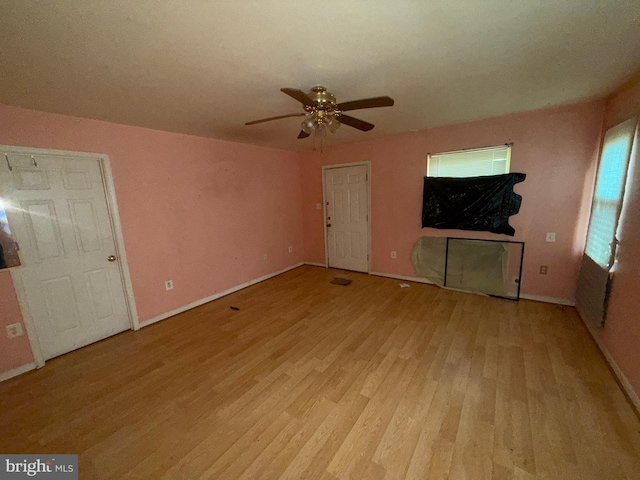 unfurnished living room featuring wood finished floors, a ceiling fan, and baseboards