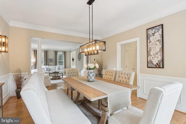 13 Lenape Ct, Mount Laurel, NJ 08054 - dining area featuring crown molding, a wainscoted wall, ornate columns, light wood-type flooring, and a chandelier