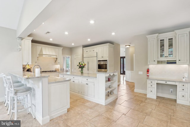 13 Lenape Ct, Mount Laurel, NJ 08054 - kitchen featuring stainless steel appliances, premium range hood, backsplash, a peninsula, and light stone counters