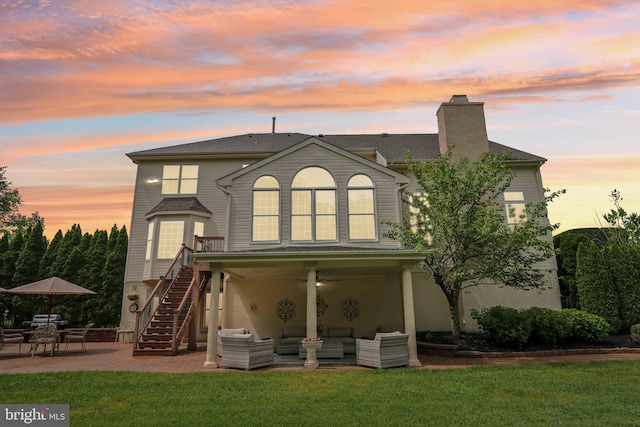 13 Lenape Ct, Mount Laurel, NJ 08054 - back of house at dusk featuring an outdoor hangout area, a patio, and a lawn