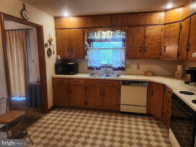kitchen with dishwasher, a sink, black microwave, range with electric cooktop, and light countertops