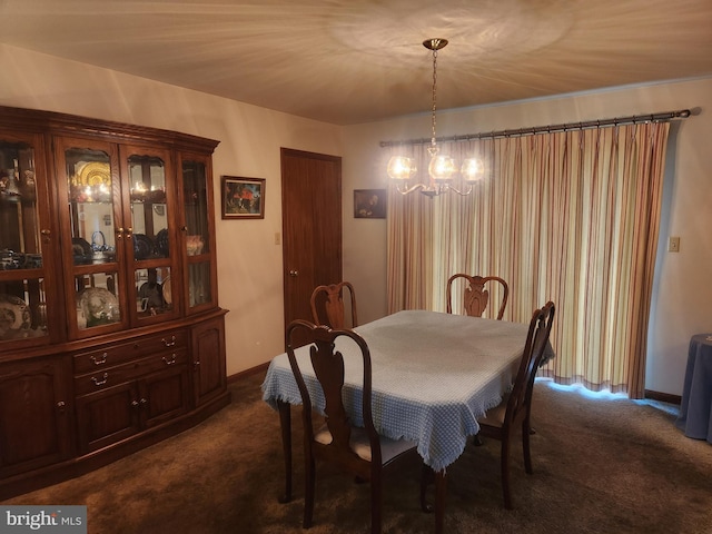 dining room with a chandelier and dark carpet