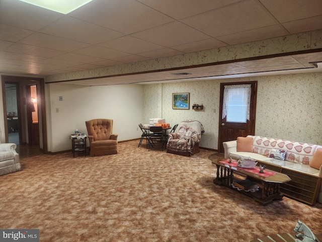 carpeted living area with a paneled ceiling