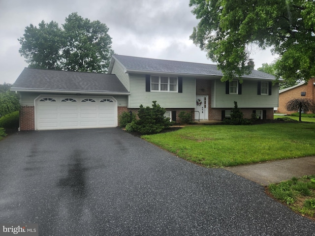view of front of house featuring driveway, a garage, a front lawn, and brick siding