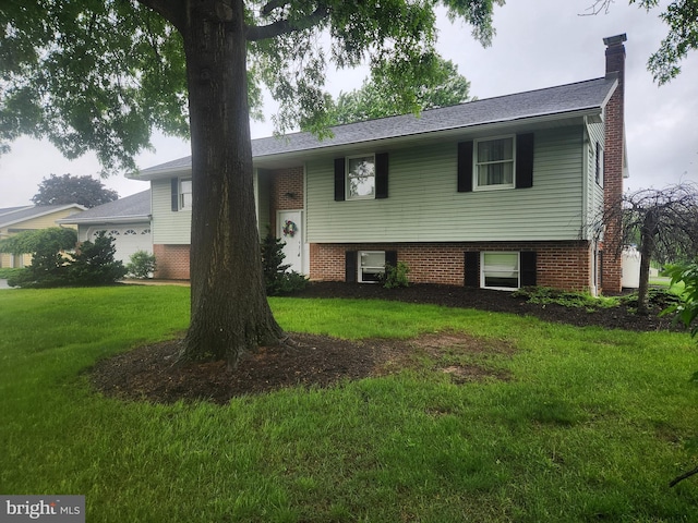 split foyer home with a front yard, a chimney, and brick siding