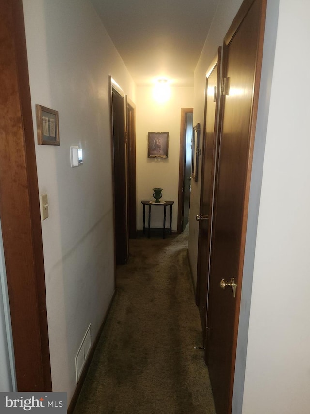 corridor featuring dark carpet