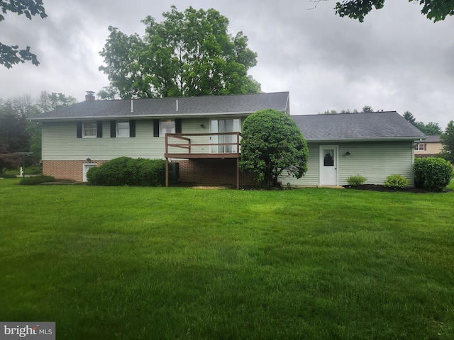 back of house featuring a yard, a deck, and a chimney