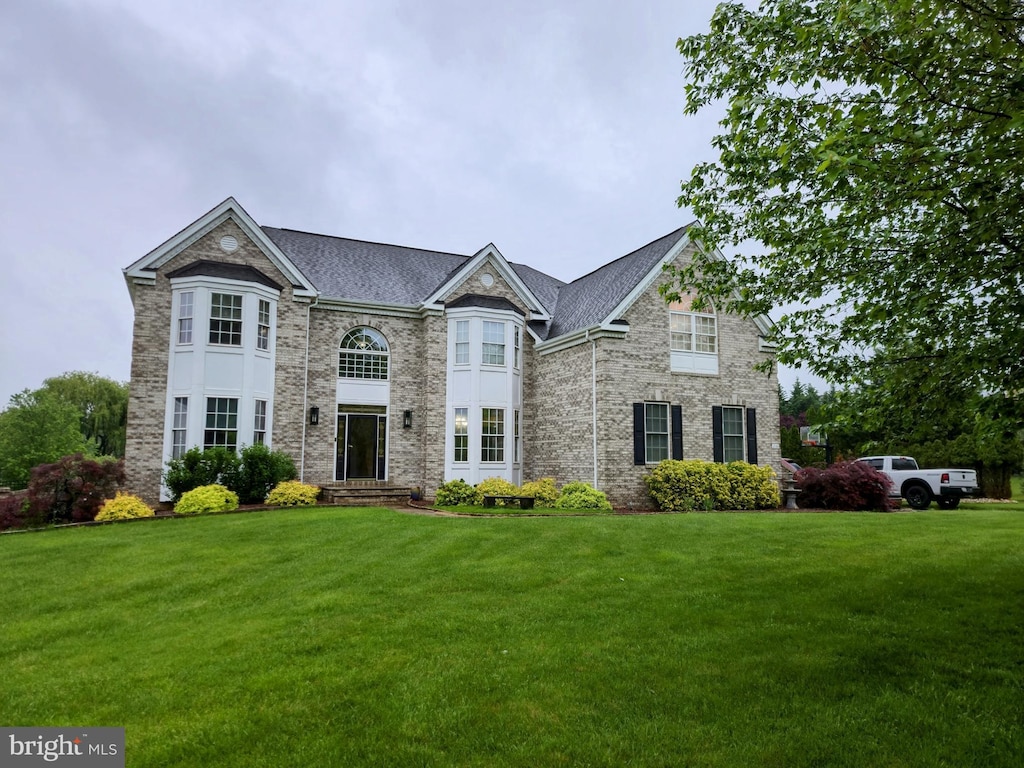 french country inspired facade featuring a front yard