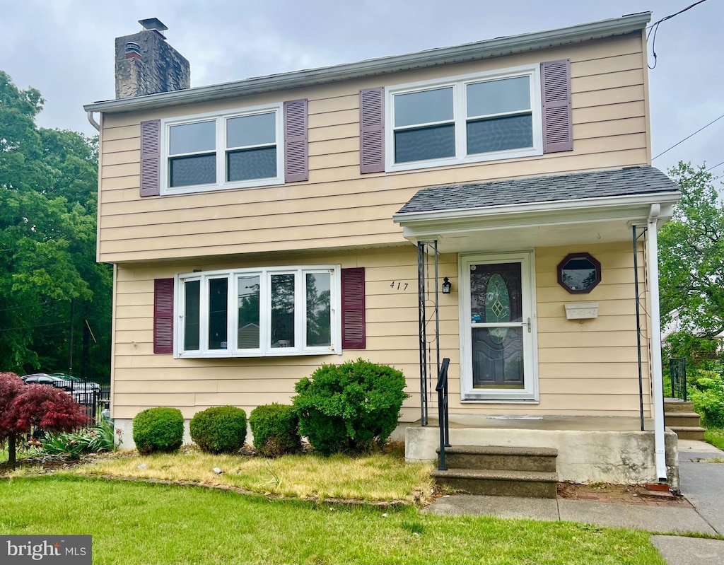 view of front of property featuring a chimney and a front lawn