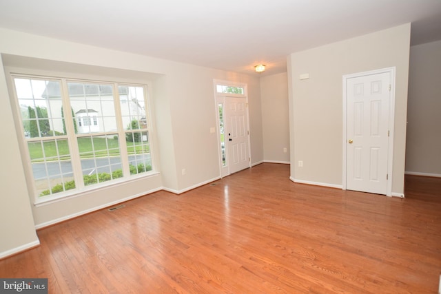 foyer entrance with light wood-type flooring and baseboards