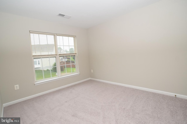 carpeted spare room featuring baseboards