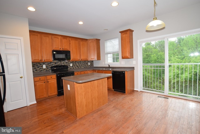 kitchen with black appliances, decorative backsplash, light wood-type flooring, a sink, and recessed lighting