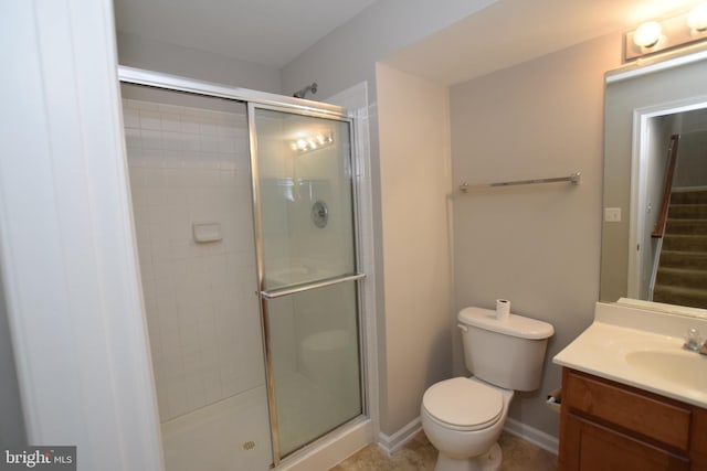 bathroom featuring a shower stall, toilet, and vanity
