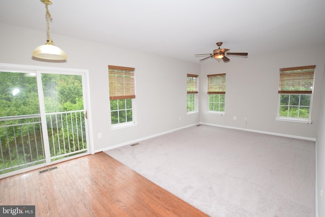 carpeted empty room with baseboards and a ceiling fan