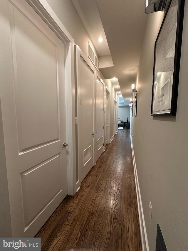 hall with dark wood-style flooring, recessed lighting, and baseboards
