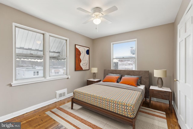 bedroom featuring baseboards, wood finished floors, and ceiling fan