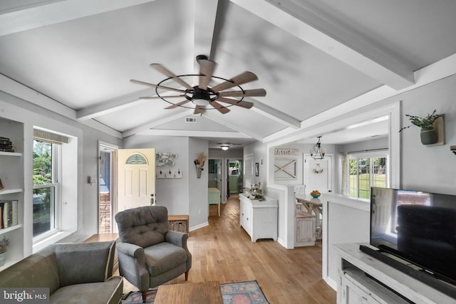 living room featuring a ceiling fan, light wood-style floors, baseboards, and a chandelier
